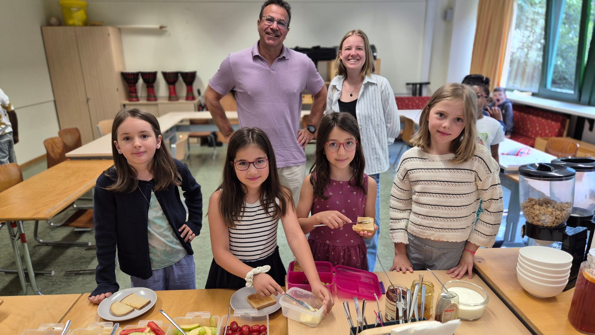 Kinder bereiten gemeinsam mit Mitarbeitenden der Deutschen Lebensbrücke und dem Spender acterience im Frühstücksklub München ein gesundes Frühstück zu.